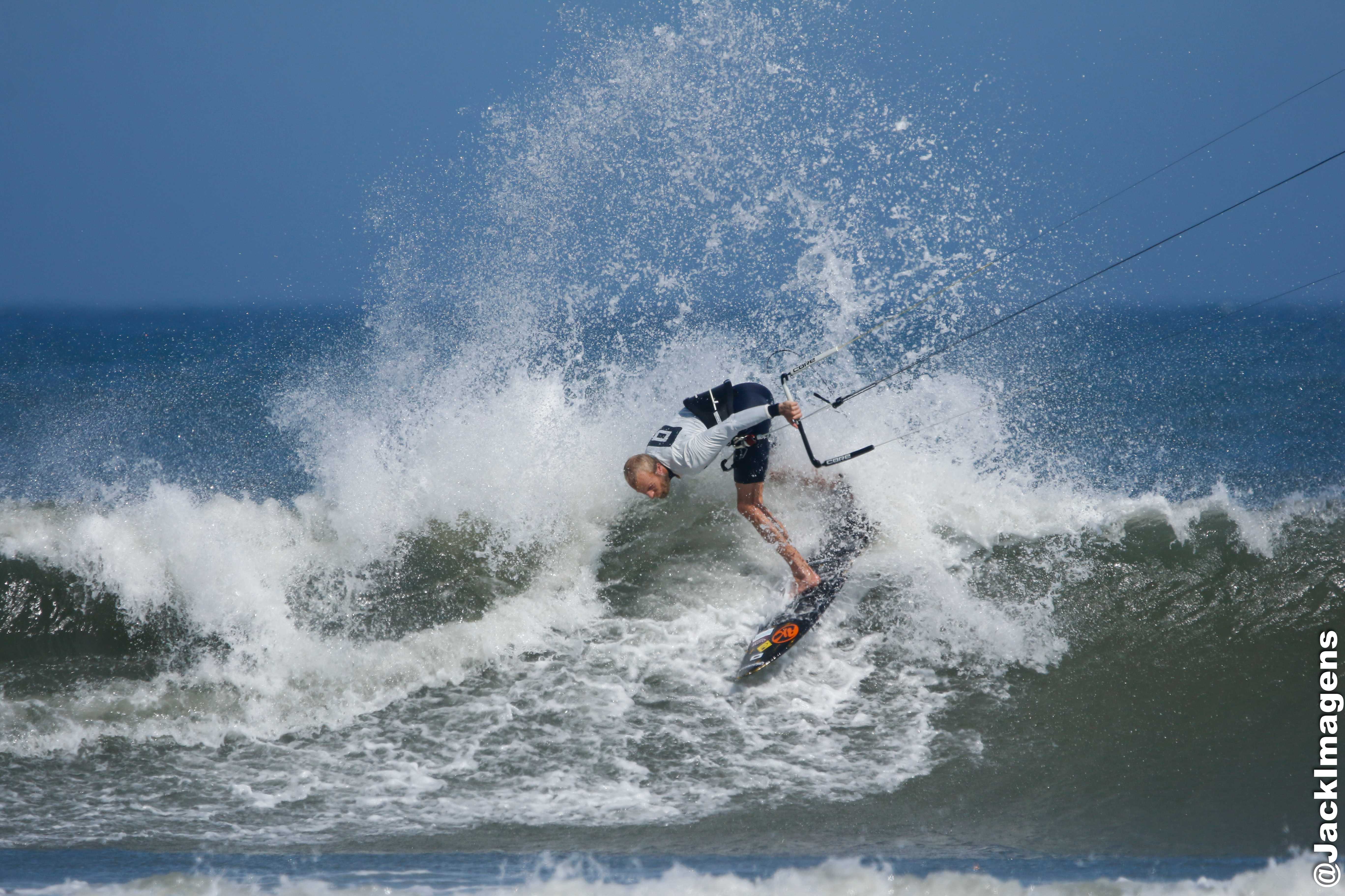 Professional kitesurfer performing maneuver with AK board