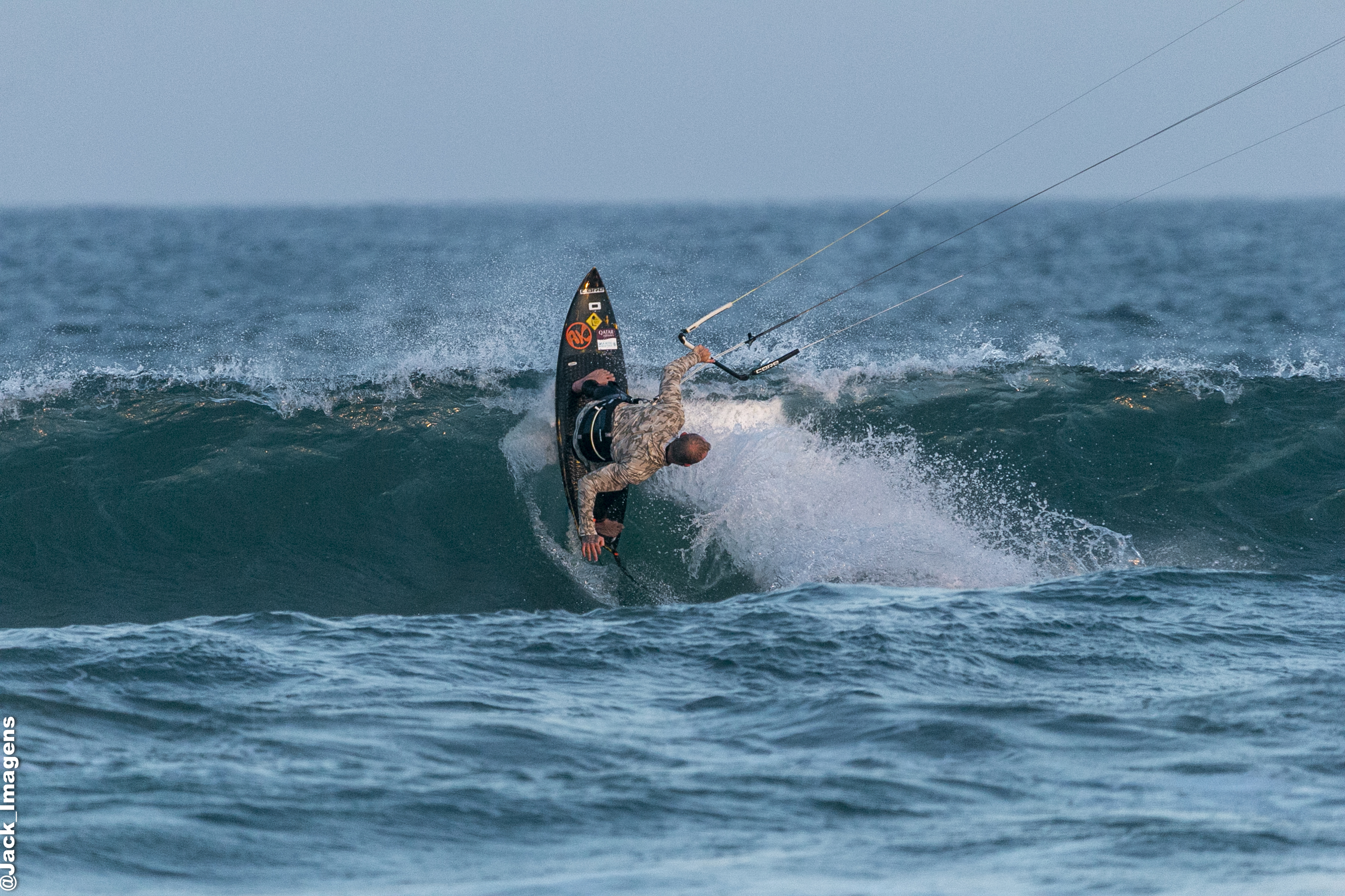 Professional kitesurfer performing maneuver with AK board